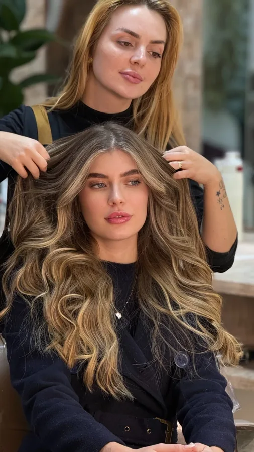 Profissional finalizando cabelos com mechas no salão